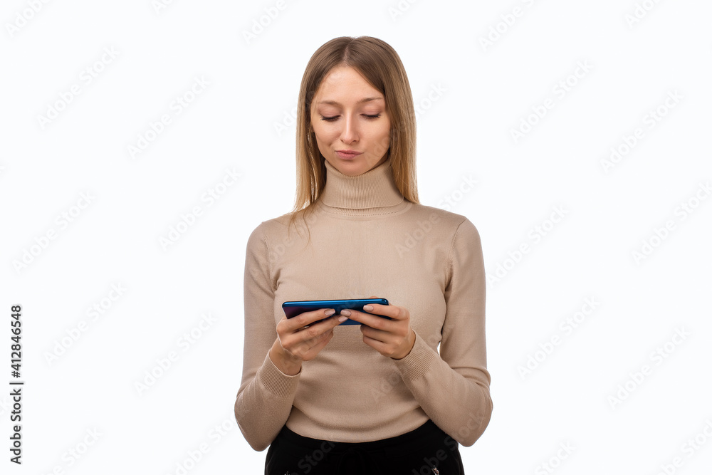 Thoughtful confused young blond woman holding her smart phone. Technology, youth and communication concept Thoughtful confused young blond woman holding her smart phone. Technology, youth and communication concept