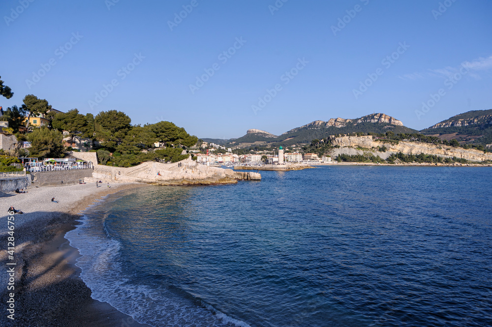 Fototapeta premium Beach and cliffs of Sormiou near Marseille, France. - The typical Mediterranean shoreline of the Calanques region near Marseille. White rocks, blue sky and sea.