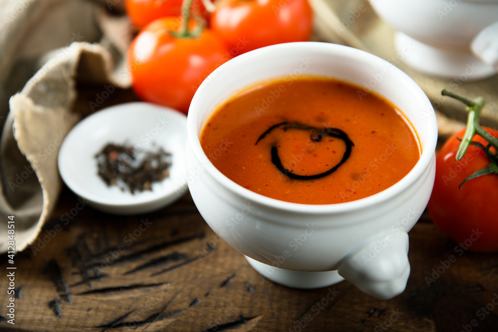 Homemade spicy tomato soup in a white bowl Homemade spicy tomato soup in a white bowl