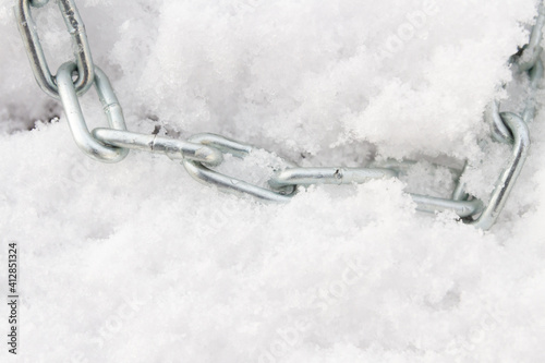 A metal chain lies on the snow in winter © Viktoriya09