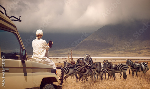 Fotografie, Obraz Woman traveler on safari-tour in Africa, traveling by car in Tanzania, watching