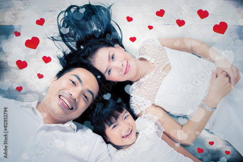 Happy family lying together with heart symbol