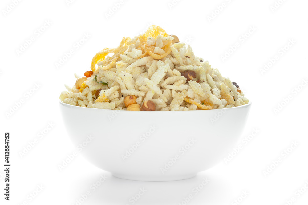 Crunchy Diet Mixture in a white Ceramic bowl made with Puffed Rice, Corn Flakes, and Curry leaves. Pile of Indian spicy snacks (Namkeen), front view, against the white background.