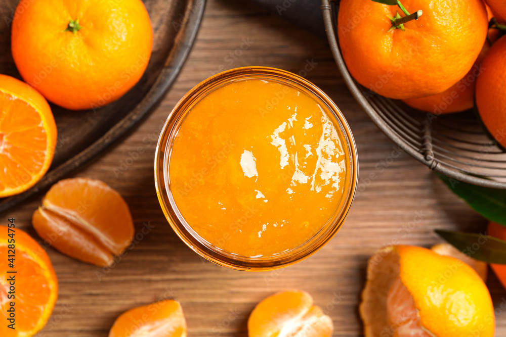 Flat lay composition with delicious tangerine jam on wooden table Flat lay composition with delicious tangerine jam on wooden table