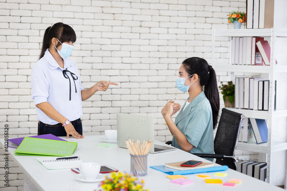 Asian women teach sign language to young girls. Using sign language and wearing medical masks at work can help reduce the spread of the Covid virus. Asian women teach sign language to young girls. Using sign language and wearing medical masks at work can help reduce the spread of the Covid virus.