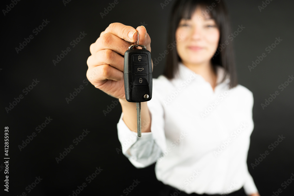 business woman hand with a car key. Isolated on black background business woman hand with a car key. Isolated on black background