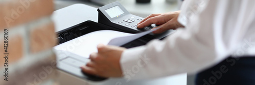 Fotografie Woman in office prints documents on printer