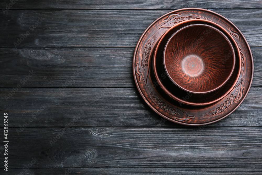 Set of clay dishes on black wooden table, top view. Space for text Set of clay dishes on black wooden table, top view. Space for text