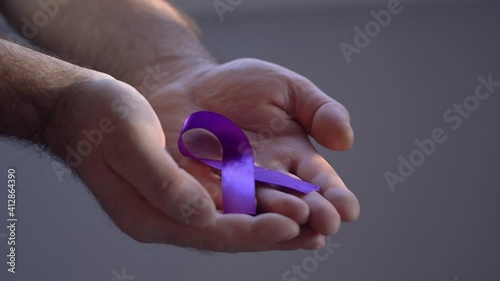 Hands holding purple ribbons, toning copy background, Alzheimer's disease, pancreatic cancer, epilepsy awareness, domestic violence awareness, fibromyalgia awareness, world cancer day photo