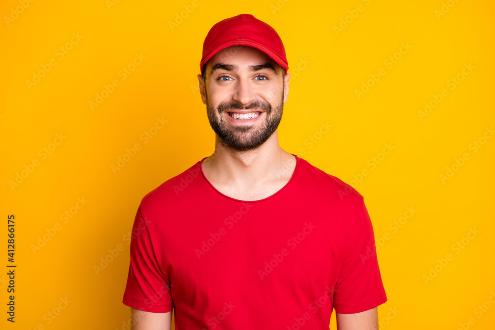 Photo portrait of delivery worker wearing red uniform cap smiling isolated on bright yellow color background