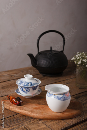 Traditional Asian Tea Set - black iron teapot and ceramic teacups for tea ceremony on a wooden table. Vintage style. With space for text. China, tea, tableware, tradition, health, tea ceremony, Asia.