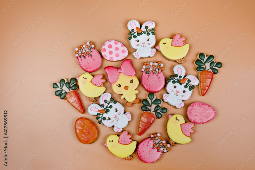 Closeup of variation of different Easter sugar cookies decorated with royal icing. Eggs, bunny, carrots and chicken on yellow background. Lovely sweet gift or postcard