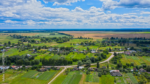 Aerial view over beautiful suburb in wide valley, in the summer. Top view to the small village with a beautiful green landscape.