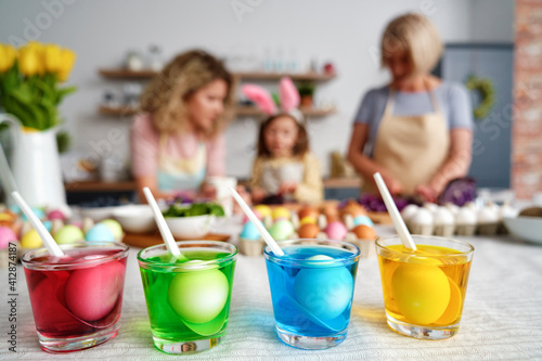 Drinking glasses with dyes for coloring eggs on the table