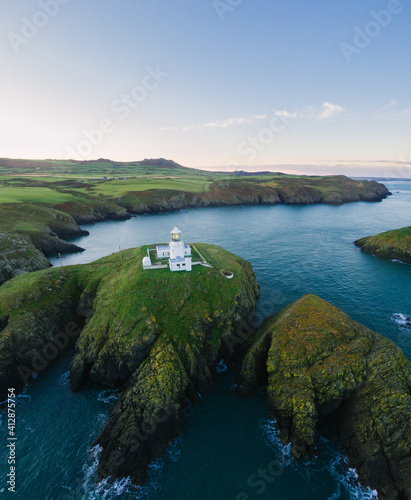 Lighthouse on coast sea cliffs from drone.