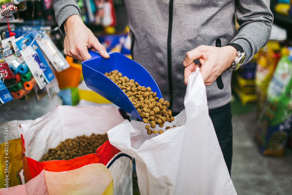 Salesman packing food for his customer in petshop.