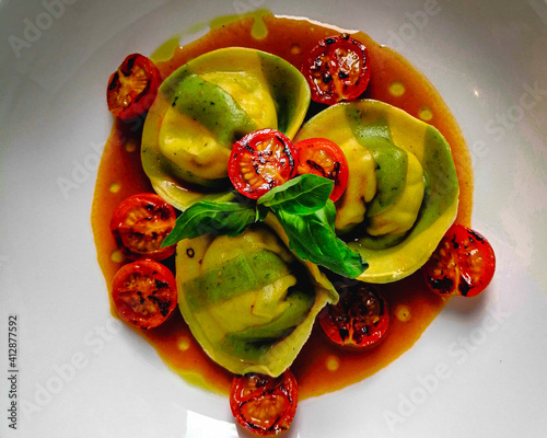 Colorful pasta dish , filled tortelli with prawns , cherry tomatoes and tomato sauce. photo