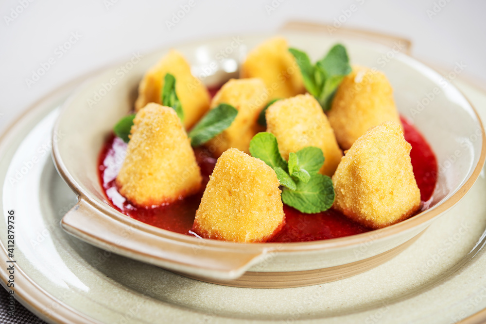 portion of fresh made fried camembert cheese served with berry jam