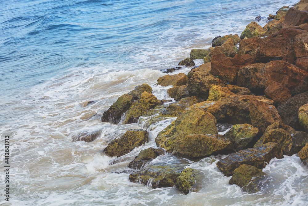 Sea surf on a rocky shore with large brown stones Sea surf on a rocky shore with large brown stones