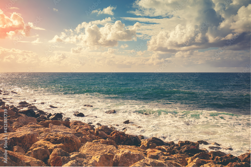 Rocky seashore on a sunny day. Nature landscape, sea with beautiful cloudy sky Rocky seashore on a sunny day. Nature landscape, sea with beautiful cloudy sky