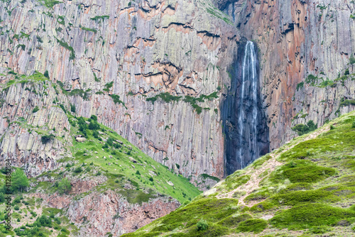 Summer landscape with mountain waterfall between two rocks