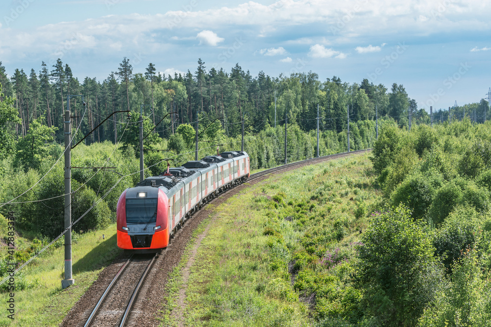 Fototapeta premium Passenger train approaches to the station at summer day.
