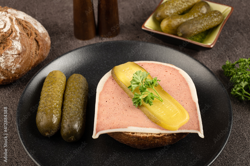Liver pate cut on a bun with parsley and cucumber