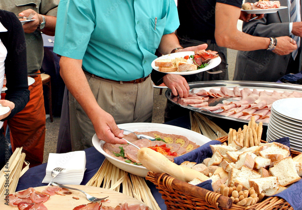 people serving themselves during a buffet, self service with different types of food  
