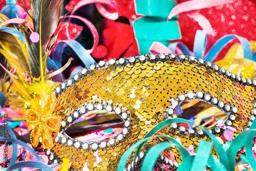 Close-up confetti and multicolored streamers with carnival mask