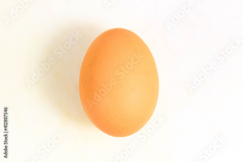 One whole raw egg on a white background.
