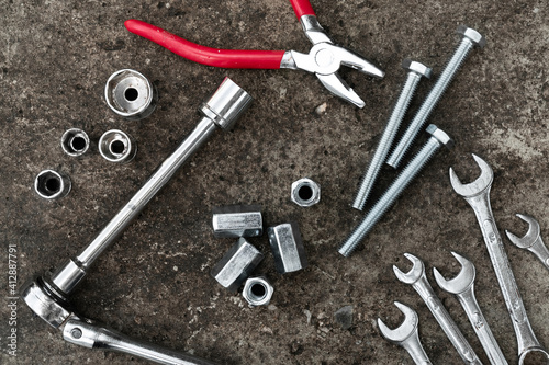 Ratched wrench, plier, bolts and wrenches on concrete background. Equipment. Engineering