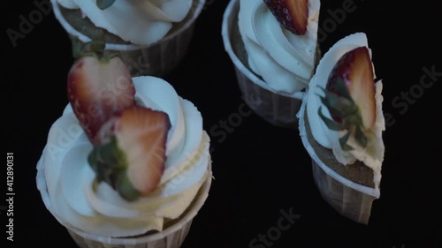 Delicious cupcake with filling inside. Fresh strawberries. Spinning table. View from above. 4K.