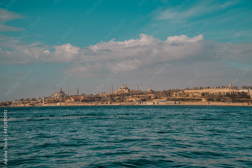 Panoramic sunset view of the Hagia Sophia Grand Mosque, Sultanahmet (Blue Mosque) Mosque and Topkapi Palace in Istanbul, Turkey seen from the Bosporus