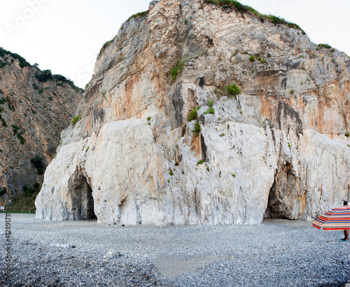 Картината върху платно A massive rock spur of the mountain ridge that downgrades to the coast and ending on a beach