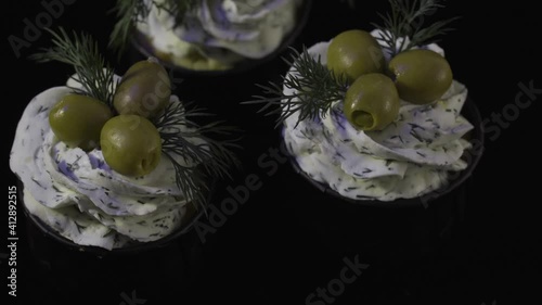 Three creamy ham and olives muffins. Top view. Delicious dessert. 4K. On a black background.