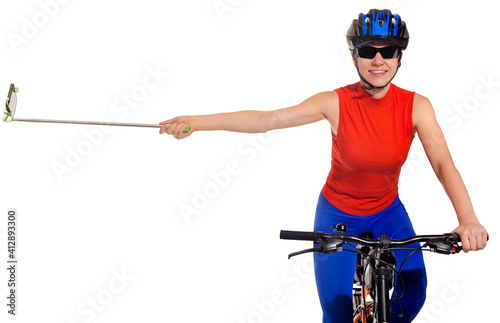 Portrait of sporty woman riding bike and using monopod to make selfie, video blogger filming himself while cycling