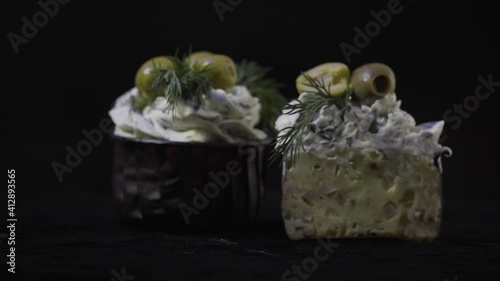 Delicious dessert. Creamy muffins with ham and olives and garlic. Sectional view. 4K. On a black background.