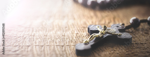 wooden rosary radiated by divine light, concept of faith and spirituality, copy space