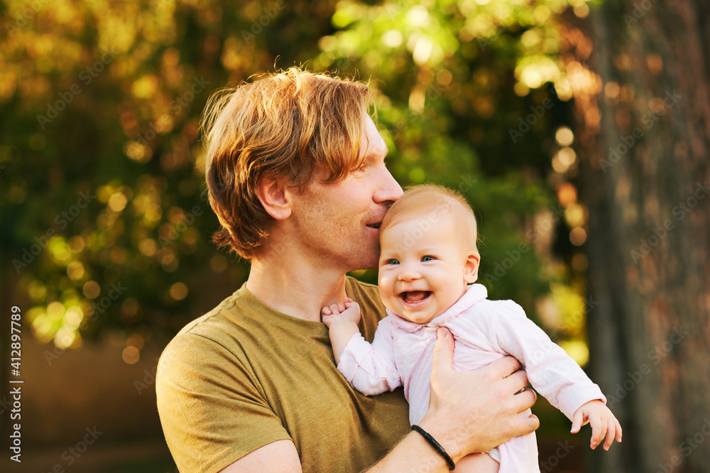 Outdoor portrait of happy young father with adorable baby Outdoor portrait of happy young father with adorable baby