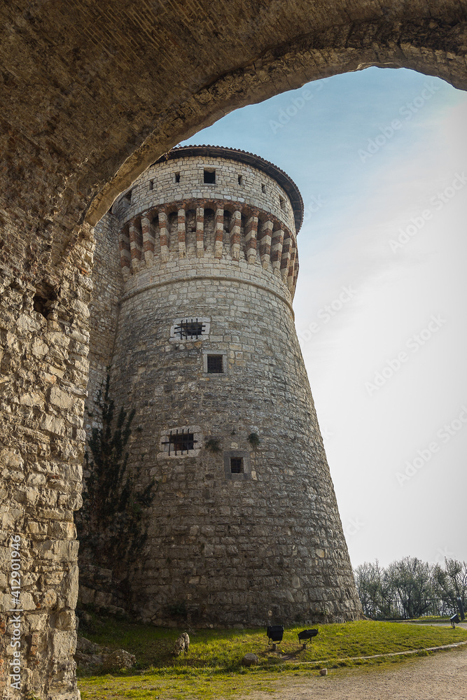 Big tower in the Medieval castle of the city of Brescia on a sunny clear day against a bright blue sky. Part of Brescia castle on the hill Cidneo. Castello di Brescia