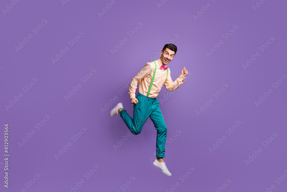 Full length profile side photo of excited fast man jump run sale hurry isolated on purple color background
