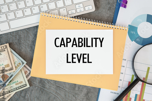 Capability level is written in a document on the office desk, money, diagram and keyboard