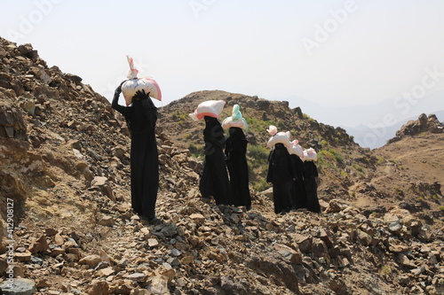 Yemeni women bring their food and drink needs across rugged mountain roads due to the war and the blockade in Yemen 