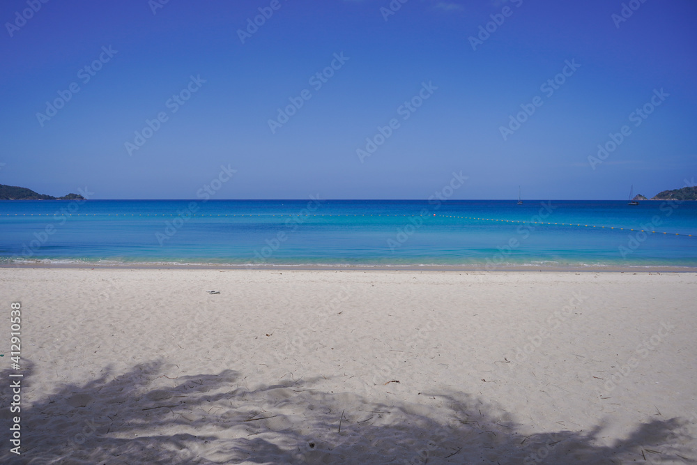Beautiful beach with white sand, turquoise ocean water and blue sky with clouds in sunny day. Panoramic view. Natural background for summer vacation. High quality photo