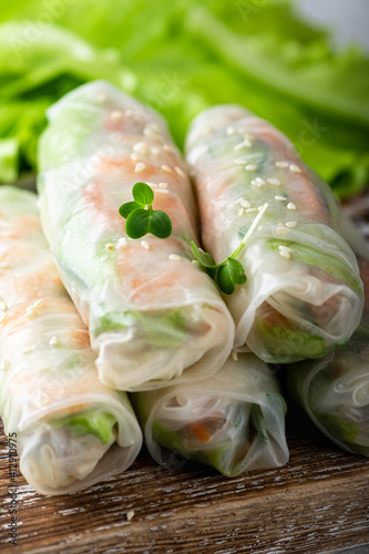 Traditional vietnamese spring rolls with shrimp, carrots, cucumber, green onions and rice noodles, selective focus