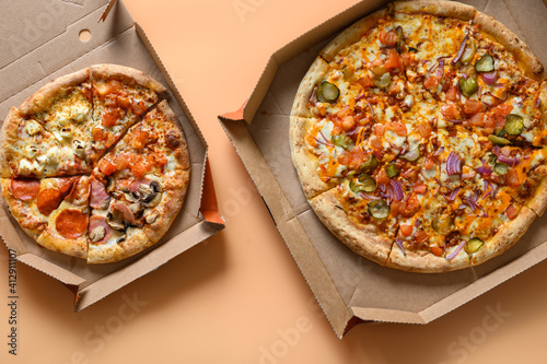 Two Italian pizzas in carton box with tomato, onion, Mozzarella cheese, sauce. Delivery food. View from above. photo