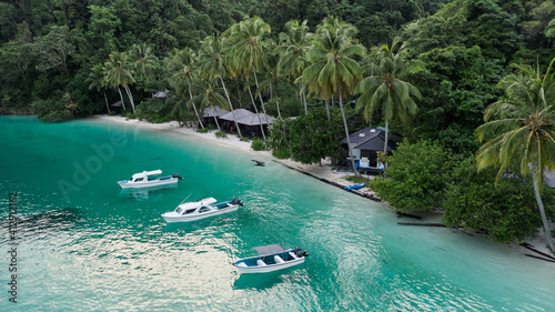 Lagoon With Boats Near Ocean Beach With Huts Among Palm Trees In Kaimana Island  Raja Ampat. Stunning View From Drone On Water Transport In Turquoise Sea Near Tropical Resort In Papua  Indonesia.