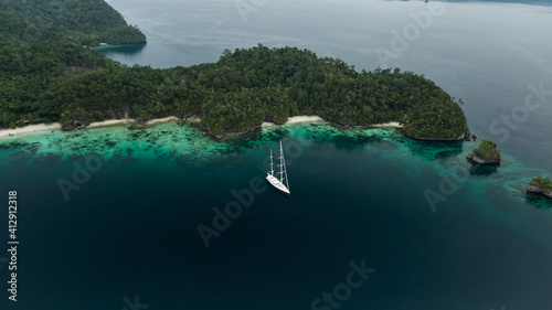 Aerial View Of Triton Bay, Raja Ampat Islands: Boat In Lagoon With Turquoise Water And Green Tropical Trees. Wide Angle Nature: Pacific Ocean And Stunning Landscape In Papua, Indonesia.