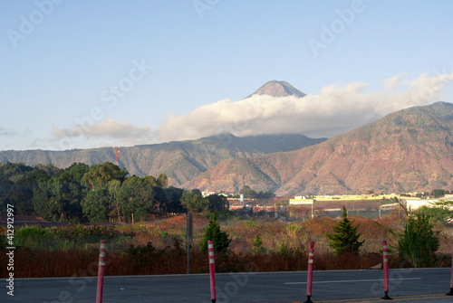Sunrise on the road in Guatemala, panoramic view of the water volcano and rural structure photo
