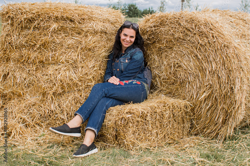 girl on sheaves of hay in summer with dark hair beautiful girl on sheaves of hay in summer with dark hair beautiful